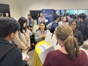 Engaged and happy students and industry representatives talk during a networking session in a large crowd.